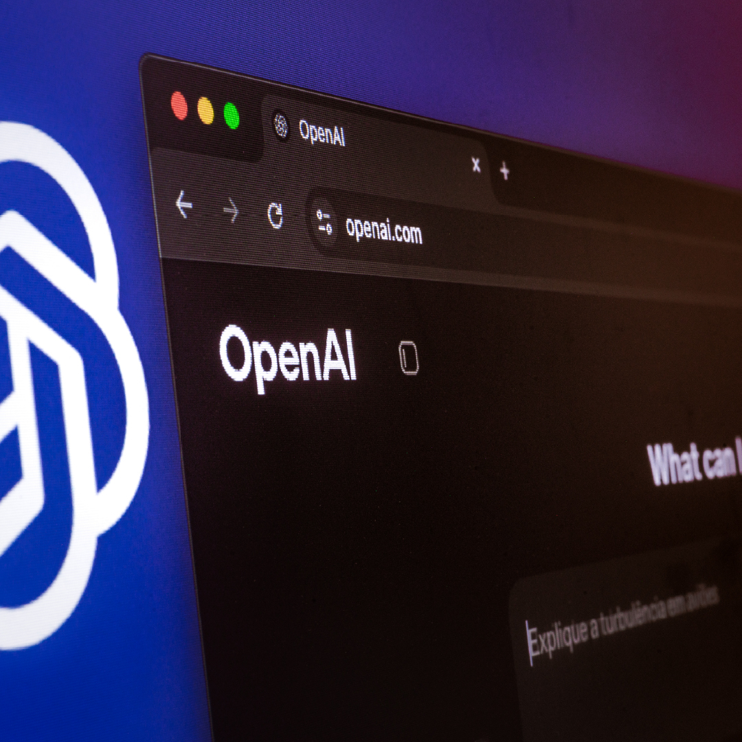 Lo schermo di un computer mostra il sito web di OpenAI in una finestra del browser con tema scuro, con il logo di OpenAI visibile sullo sfondo.